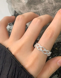 Close-up of S925 sterling silver triple interwoven braided ring on a finger
