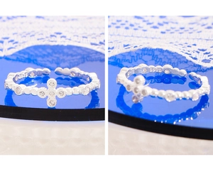Detail of S925 sterling silver stamp and zircon cross design on an open ring