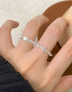 Detail of S925 sterling silver beaded ring with zircon cross and pearl on finger