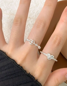 Detail view of S925 sterling silver rings with heart and cross motifs on a model