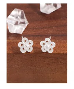 Close-up of S925 silver hollow flower stud earrings with a lustrous white pearl center