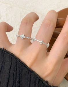 Detail of S925 sterling silver cross ring with zircon accents worn on finger