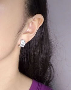 Close-up of S925 sterling silver earrings with square zircon crystals on the ear lobe