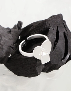 Nahaufnahme von S925 Sterlingsilber-Herzring mit Vorhängeschloss auf Holzkohle