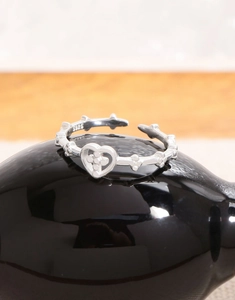 Close-up of S925 sterling silver open ring with hollow heart and floral cross detail