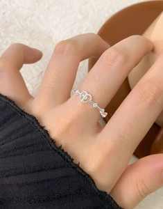 Detailed view of S925 sterling silver heart cross open ring worn on a finger