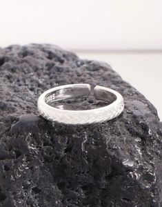 Macro detail of S925 sterling silver braided ring showing the engraved hallmark and texture