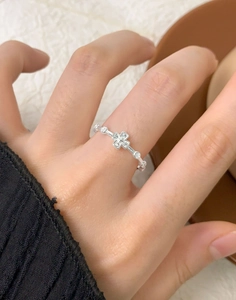 Macro detail of S925 silver ring featuring a zircon cross clover design on finger