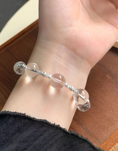 Close-up of clear crystal beads and S925 sterling silver charms on a women's bracelet