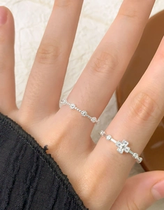 Close-up of S925 sterling silver zircon cross ring and beaded band worn on a finger