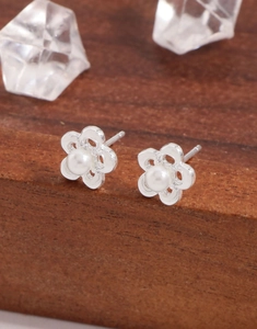 Macro shot of hollow flower earrings with shell pearls and S925 sterling silver finish