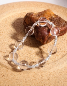 Macro view of crystal beads and silver cylindrical spacers on a natural stone base