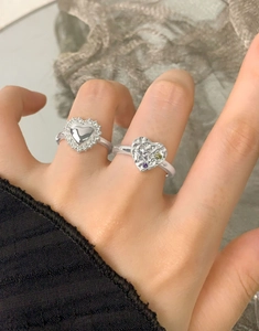 Macro shot of silver heart rings with lava texture and colorful cubic zirconia detail
