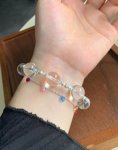 Detailed view of a layered bracelet with clear crystal beads and multi-color stone charms