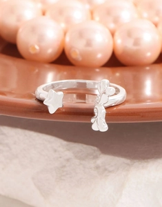 Macro detail of S925 sterling silver star and rabbit open ring on a pearl background