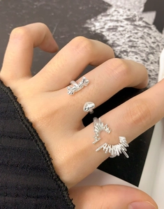 Detailed close-up of S925 sterling silver heart and wing rings worn on fingers