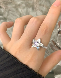 Gros plan d'une bague étoile en argent S925 avec zircon cœur violet et texture martelée