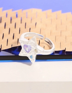 Détail macro de bague étoile en argent S925 avec zircon cœur violet et gemmes colorées