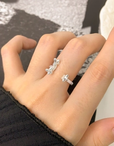 Detailed close-up of a twisted silver-toned adjustable wing ring on a finger