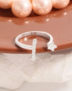 Macro view of silver adjustable ring featuring a star charm and textured bar detail