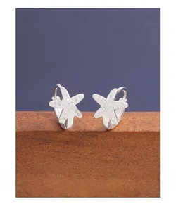 Macro shot of S925 sterling silver starfish earrings with cubic zirconia on wood