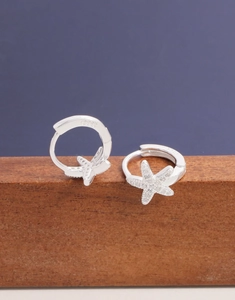 Macro shot of S925 sterling silver starfish earrings with cubic zirconia on wood