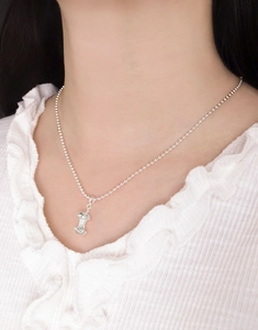 Detail of S925 sterling silver apple core pendant on ball chain worn by model