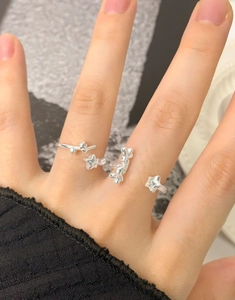 Detail of silver S925 star and fluid open rings on hand with a modern minimalist aesthetic