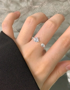 Detailed view of S925 sterling silver open ring with zircon stone and silver bead on finger