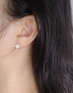 Close-up of S925 silver starfish earrings with pavé zircons worn by a model