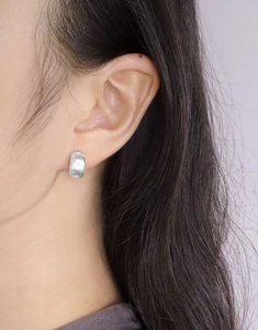 Close-up of S925 sterling silver star stud earring with a brushed matte texture finish