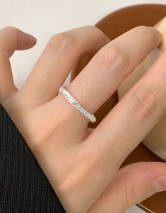 Detail of matte frosted silver Mobius ring with sparkling texture on female finger