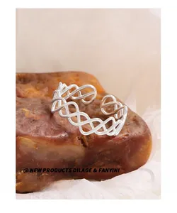 Vue détaillée d'une bague irrégulière en maille argentée sur pierre et fond de tissu blanc