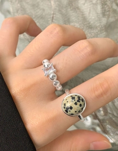 Macro detail of S925 silver rings with natural spotted stone and rectangle zircon