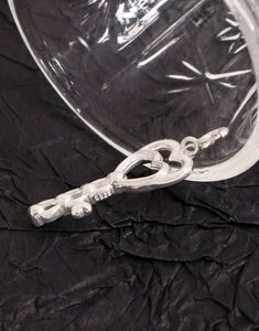 Macro view of S925 sterling silver key pendant showing double heart shape and S925 stamp