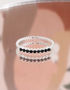 Macro detail of S925 silver twisted ring band with eight black cubic zirconia stones