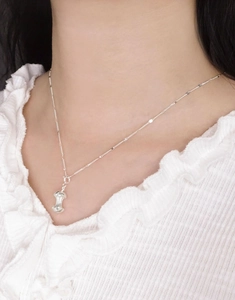 Close-up of a minimalist S925 sterling silver apple core pendant on a delicate chain