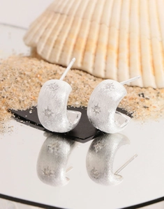 Detailed macro view of brushed S925 sterling silver star-studded hoop earrings