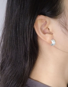 Close-up of S925 sterling silver starburst earring with brushed matte finish on ear