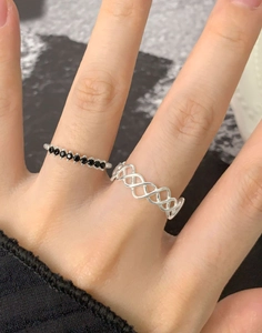 Detail of silver twisted ring set with black zircons worn on finger close-up shot