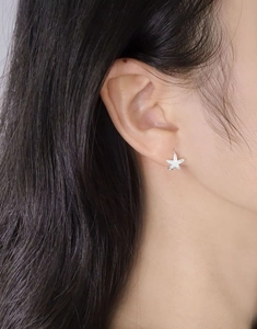 Close-up of S925 sterling silver starfish earrings with cubic zirconia on a model ear