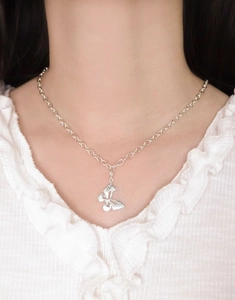 Detailed view of an S925 sterling silver butterfly pendant worn on a silver chain