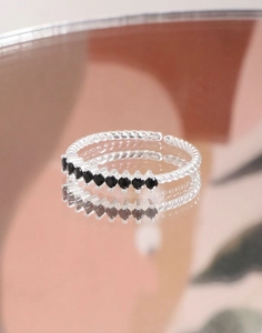 Macro view of silver twisted band ring featuring seven inlaid black zircon stones