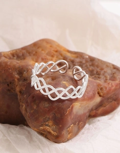 Vue détaillée d'une bague en argent à mailles creuses sur un fond de pierre naturelle