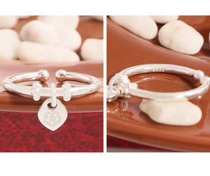 Detail view of S925 sterling silver ring featuring a heart charm and floral engraving