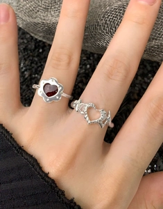 Dettaglio del set di anelli a fiore in argento S925 con gemma a cuore rosso e fascia gotica