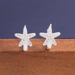 Sparkling S925 sterling silver starfish hoop earrings with zircon pavé on a wooden stand
