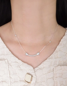 Detailaufnahme der S925 Sterling Silber Herz- und Perlenkette getragen zum Tweed-Oberteil