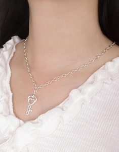 Close-up of S925 sterling silver heart key pendant on O-chain worn by a model