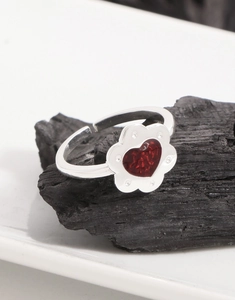 Dettaglio anello fiore in argento S925 con gemma cuore rosso e petali luccicanti